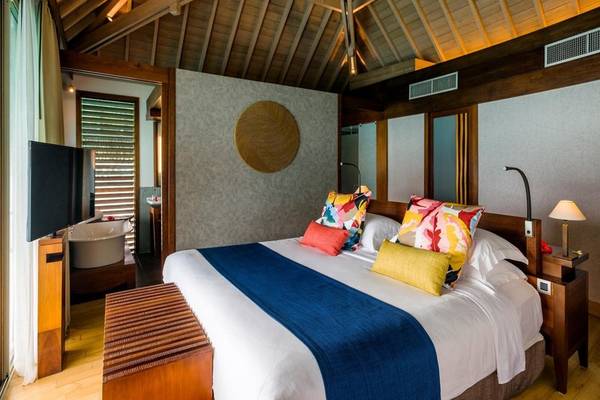 Hotelzimmer im InterContinental Bora Bora Resort mit Bett, Fernseher und Badewanne.