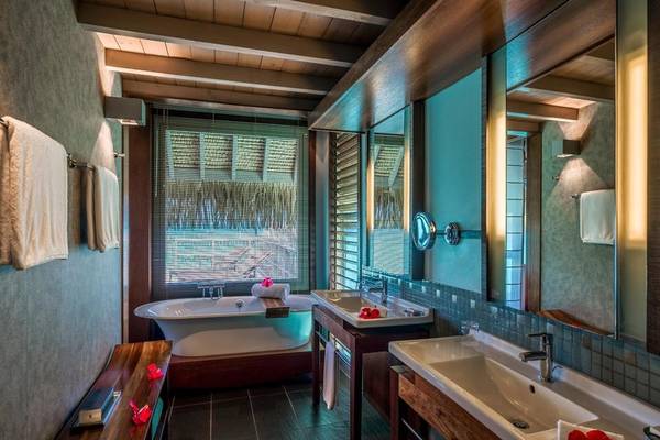 Luxuriöses Badezimmer im InterContinental Bora Bora mit Badewanne, Waschbecken und Fenstern.