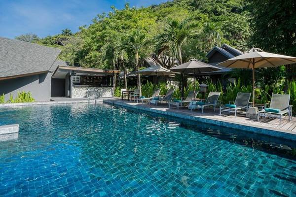 Pool-Lounge-Bereich des KC Grande Resort Koh Chang mit Sonnenliegen und Schirmen.