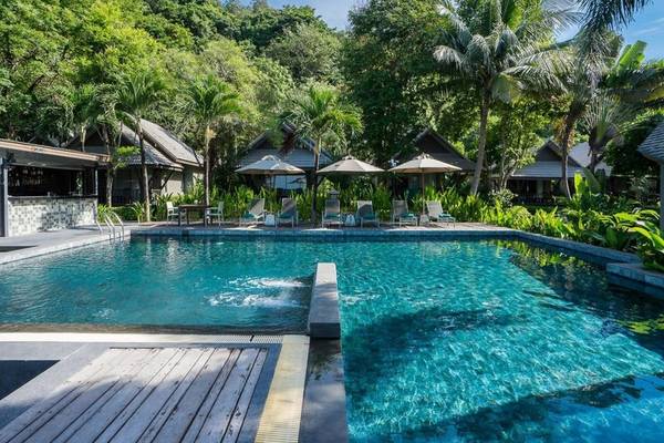 Außenpool im KC Grande Resort Koh Chang mit Sonnenliegen und Sonnenschirmen.