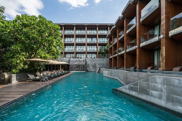 Außenpool des KC Grande Resort Koh Chang mit Loungestühlen und Sonnenschirmen.