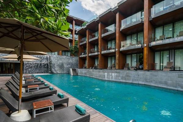 Außenpool des KC Grande Resort Koh Chang mit Loungeliegen und Sonnenschirmen