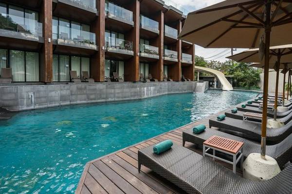 Außenpool des KC Grande Resort Koh Chang mit Sonnenliegen und Sonnenschirmen.