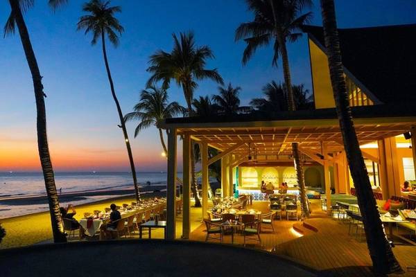 Abendessen im Freien am KC Grande Resort Koh Chang mit Blick auf den Ozean und Palmen.