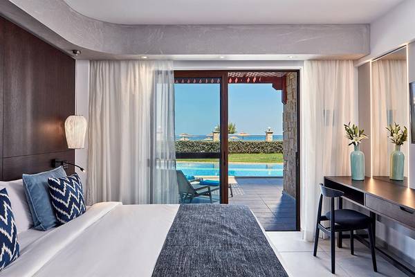 Innenansicht eines Hotelzimmers im Atlantica Caldera Palace mit Blick auf den Pool.