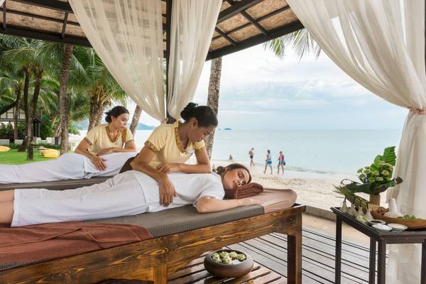 Massagestuhl am Strand im KC Grande Resort Koh Chang mit Blick auf das Meer und Palmen