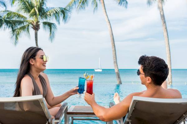 Ein Paar mit Cocktails am Pool im KC Grande Resort Koh Chang
