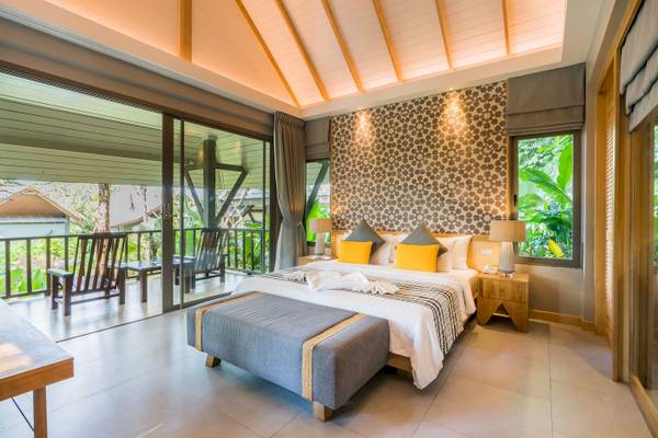 Schlafzimmer im KC Grande Resort Koh Chang mit großem Bett, Balkon und Blick auf die Natur.