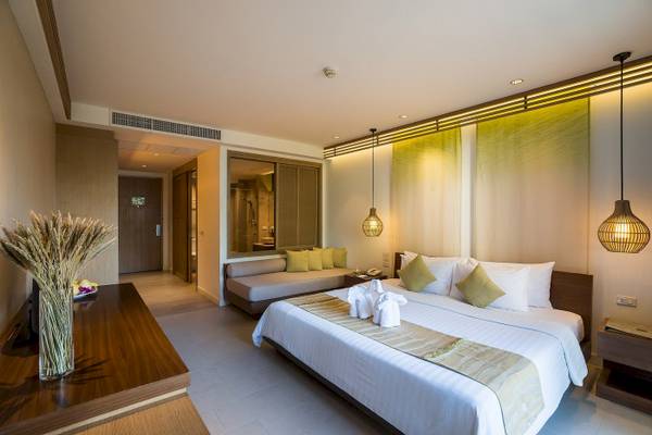 Schlafzimmer des KC Grande Resort Koh Chang mit Bett, Sofa, Tisch und Deko.