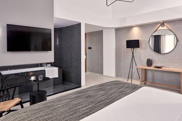 Schlafzimmer im Atlantica Caldera Palace Hotel mit Fernseher, Bett, Tisch und Badezimmer
