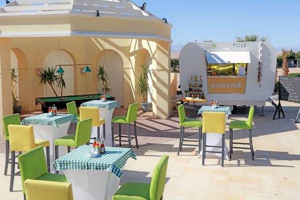 Außenbereich des Lemon & Soul Garden Makadi Hotels mit einem Pizzawagen, Tischen und Stühlen.