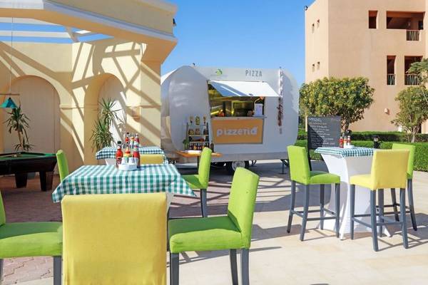Außenbereich des Lemon & Soul Garden Makadi Hotels mit Pizza-Mobil und Tischen.