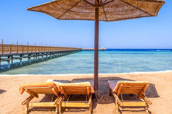 Strand mit Sonnenschirm und Liegen am Grand Makadi Hotel.