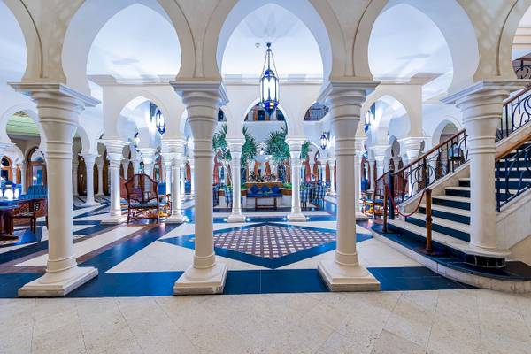 Empfangsbereich des Grand Makadi Hotels mit weißen Säulen und blauen Bodenfliesen.