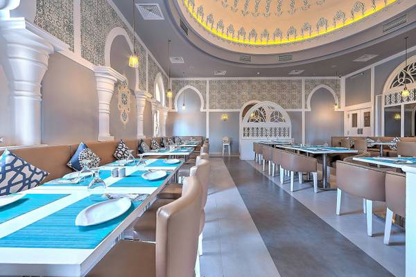 Innenbereich des Grand Makadi Hotels, Restaurantbereich mit gedeckten Tischen und Stühlen.