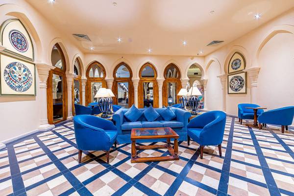 Lobby des Grand Makadi Hotels mit blauen Möbeln und einem Tisch.