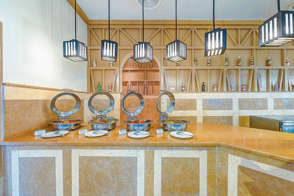 Buffet-Tisch im Grand Makadi Hotel mit Speisen in Metallschüsseln und hängenden Laternen.