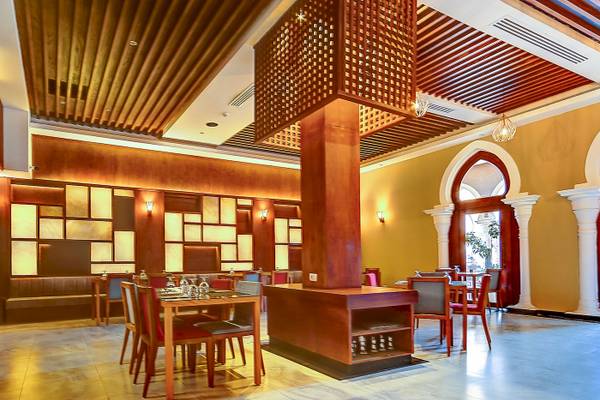 Innenbereich des Grand Makadi Hotels mit Holzmöbeln, hohen Decken und gelben Wänden.