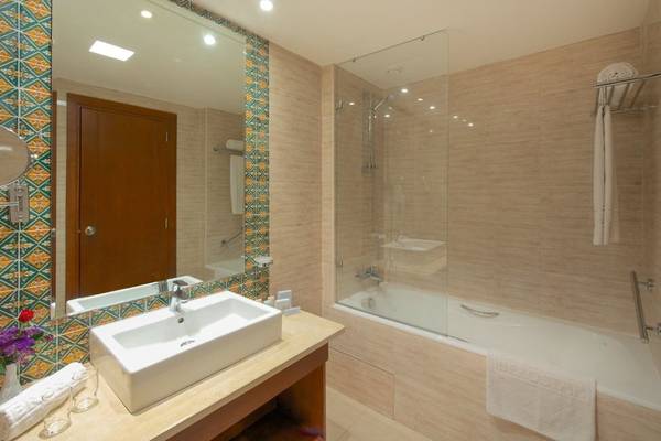 Badezimmer im Iberostar Selection Royal El Mansour Hotel mit Badewanne, Dusche und Waschbecken.