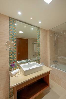 Badezimmer im Iberostar Selection Royal El Mansour mit Waschbecken, Spiegel und Badewanne.