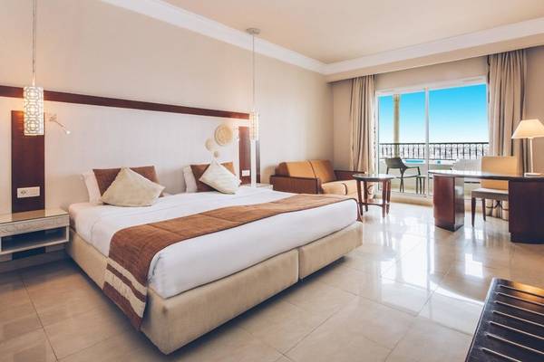 Innenansicht eines Hotelzimmers im Iberostar Selection Royal El Mansour mit Bett, Balkon und Schreibtisch.