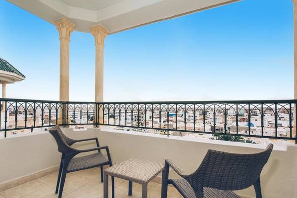 Hotelbalkon mit Blick auf die Stadt, zwei Stühle und ein Tisch