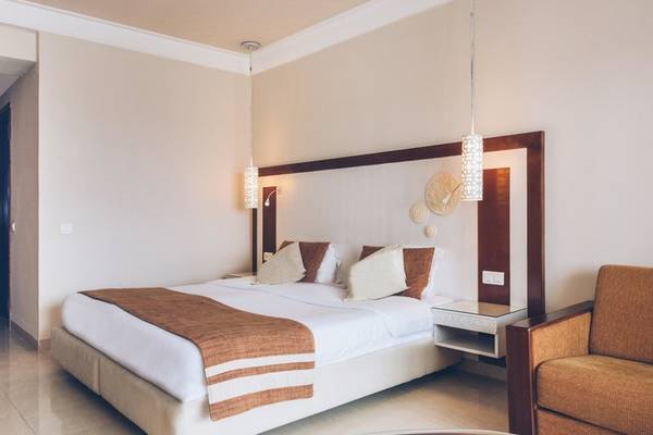 Ein elegantes Hotelzimmer im Iberostar Selection Royal El Mansour mit einem großen Bett und bequemen Sesseln.