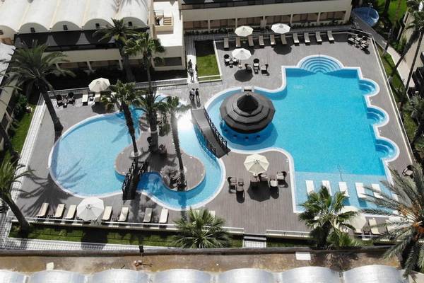 Luftaufnahme des Paradis Palace Hotels mit Swimmingpool, Liegestühlen und Sonnenschirmen.