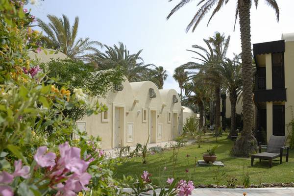 Außenbereich des Paradis Palace Hotels mit Reihen von Zimmern, Palmen und Garten