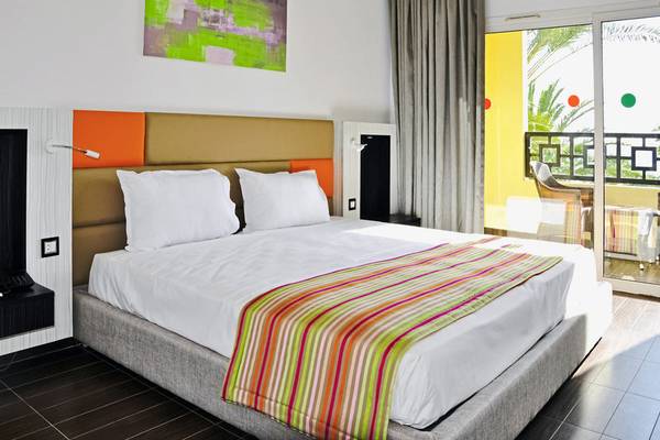 Das moderne Zimmer im Paradis Palace Hotel mit einem großen Bett und buntem Bettdecken.
