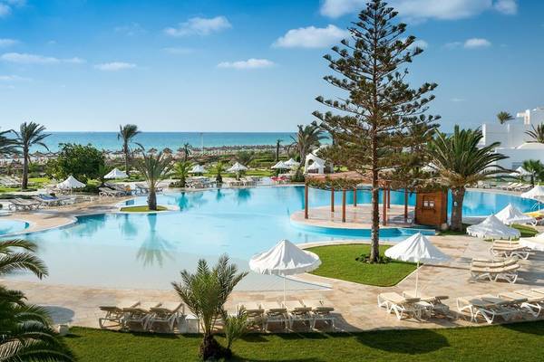 Außenbereich des Iliade Djerba by Magic Hotels mit großem Pool und Liegestühlen.