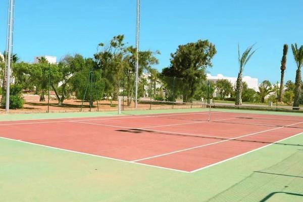 Tennisplatz im Hotel Iliade Djerba by Magic Hotels mit grünen und roten Feldern.