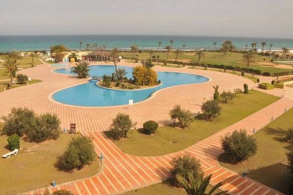 Luftaufnahme des Nour Palace Resort & Thalasso mit einem großen Schwimmbad und Blick auf den Ozean.