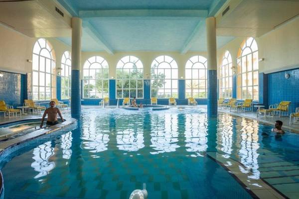 Innenpool des Nour Palace Resort & Thalasso mit zwei Schwimmern und gelben Sonnenliegen