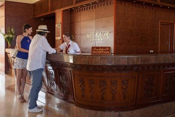 Empfangsbereich des Nour Palace Resort & Thalasso mit Rezeptionistinnen und Gästen.