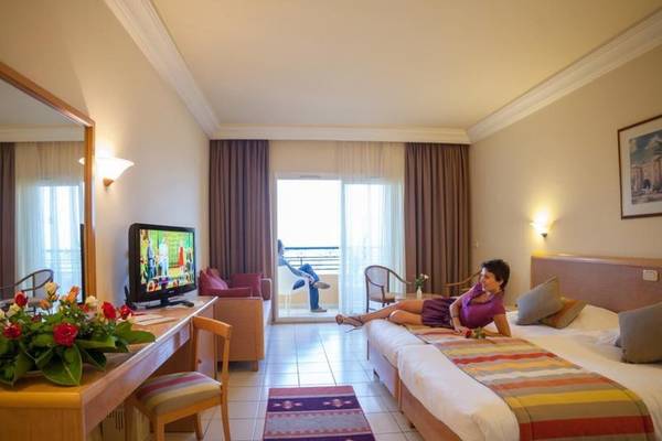 Doppelbett im Hotelzimmer des Nour Palace Resort & Thalasso mit Terrasse.
