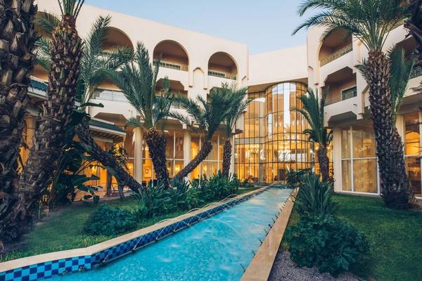 Außenansicht des Iberostar Waves Averroes Hotels mit Pool und Palmen