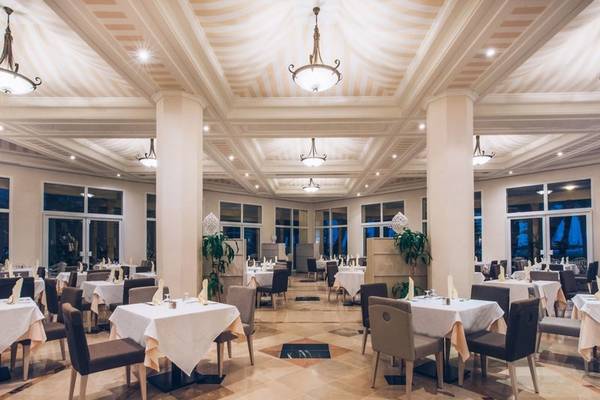 Innenansicht des Restaurants im Iberostar Waves Averroes Hotel mit elegant eingerichteten Tischen und Stühlen.