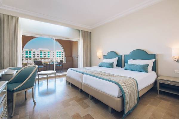 Doppelzimmer-Innenansicht im Iberostar Waves Averroes Hotel mit zwei Betten, Fenster und Terrassenblick.
