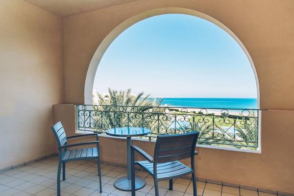 Balkon mit Meerblick im Iberostar Waves Averroes Hotel, mit zwei Stühlen und einem Tisch.