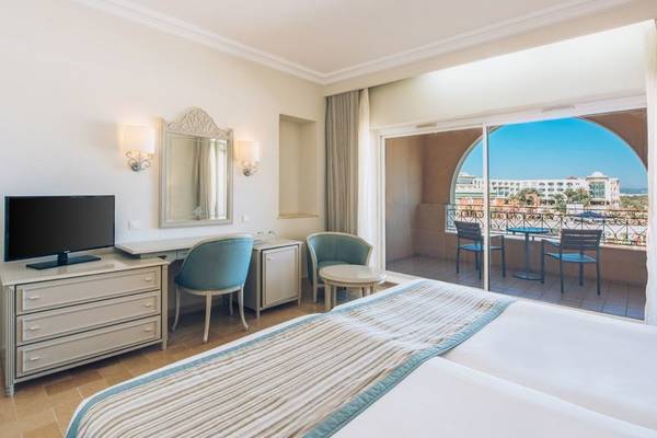 Hotelzimmer im Iberostar Waves Averroes mit Balkon, Fernseher und Schreibtisch.