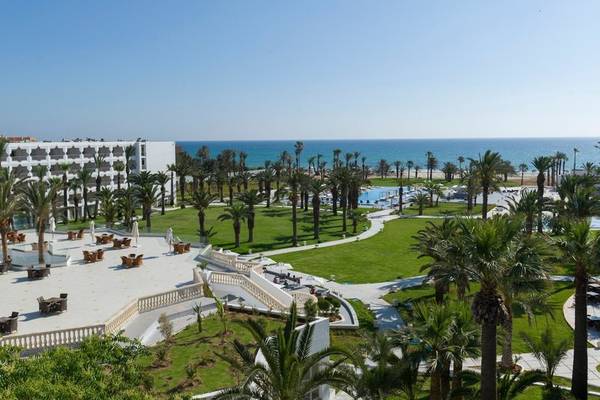 Außenansicht des JAZ Tour Khalef Hotels mit Palmen und Swimmingpools.