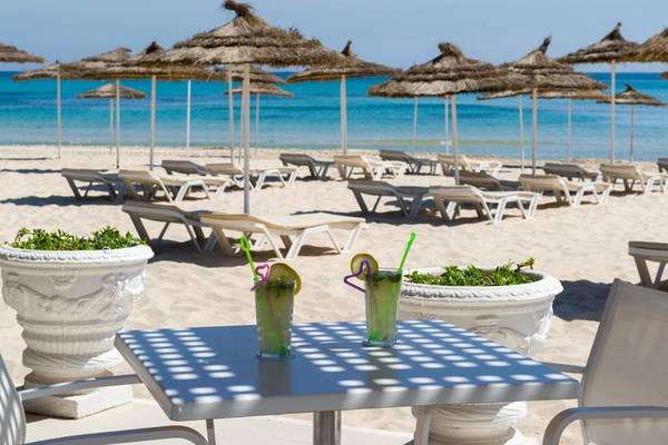 Strand mit Sonnenliegen und Getränken im JAZ Tour Khalef Hotel.