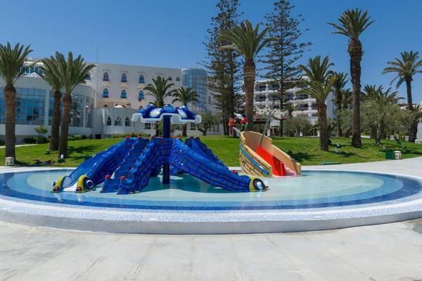 Wasserspielplatz des JAZ Tour Khalef Hotels mit bunten Rutschen vor weißem Gebäude