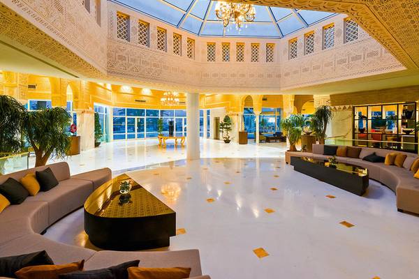 Lobby des JAZ Tour Khalef Hotels mit großen Sofas, goldenen Mustern auf dem Boden und einer großen Glaskuppel