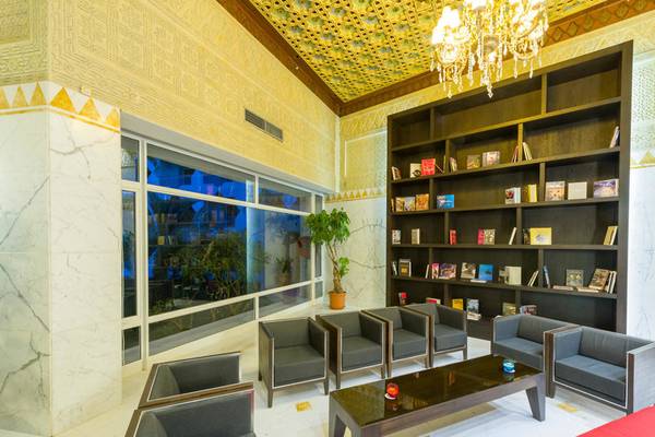 Hotellobby des JAZ Tour Khalef mit Sofas, einem Tisch, einem Bücherregal und einer großen Fensterfront.