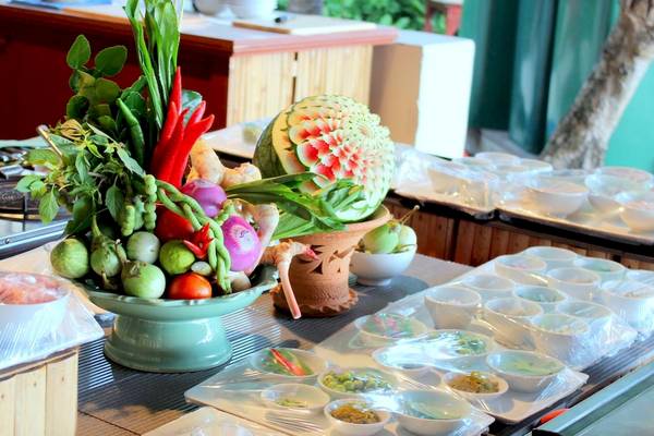 Buffet-Tisch im Banana Fan Sea Resort mit Gemüse, Obst und vorbereiteten Gerichten.