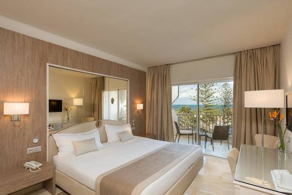 Ein elegantes Hotelzimmer mit einem großen Bett, einem Balkon und Meerblick im JAZ Tour Khalef.