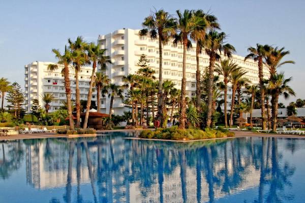 Außenpool des Sahara Beach AquaPark Resorts mit weißen Gebäuden im Hintergrund und Palmen