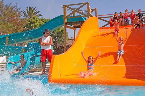 Kinder und Erwachsene genießen die Wasserrutsche im Sahara Beach AquaPark Resort.